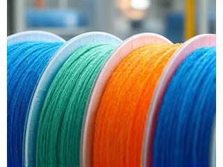 Botol plastik didaur ulang menjadi benang tekstil, menunjukkan proses inovatif.
