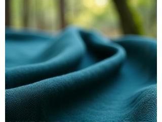 Serat Tencel Lyocell yang halus digambarkan keluar dari sari kayu dengan latar belakang hutan yang hijau.